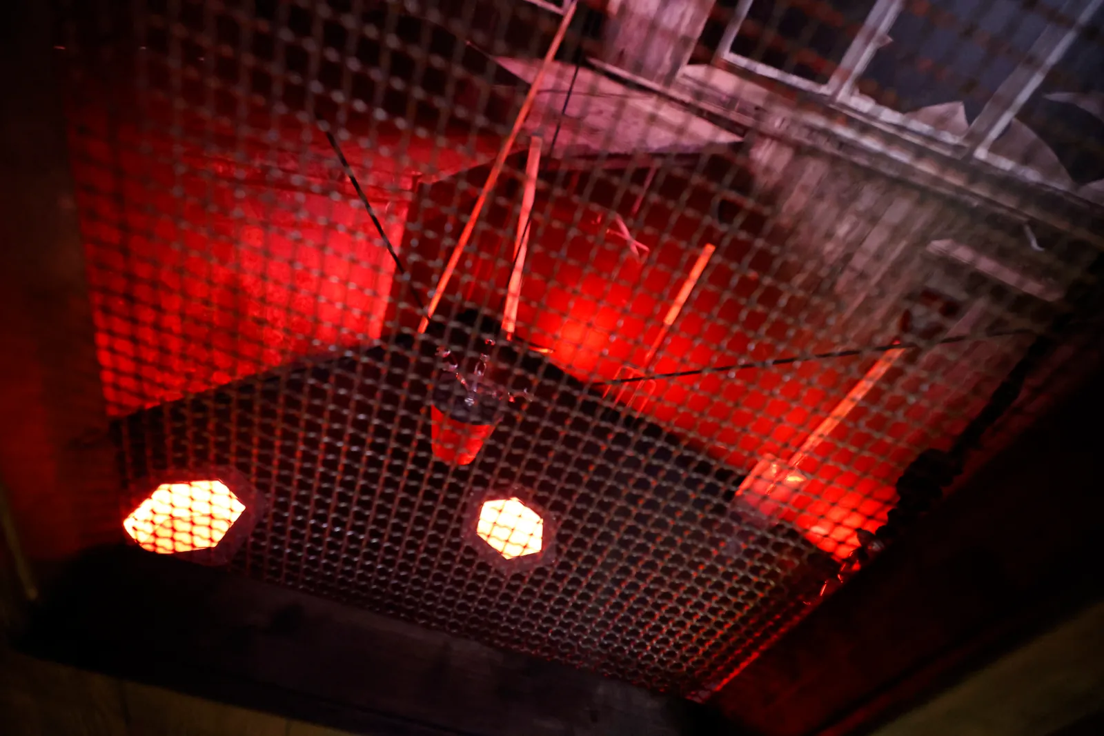 Une cellule éclairée en rouge, un filet tendu au plafond